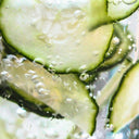 Fresh cucumber slices with water droplets, emphasizing hydration and natural skincare elements