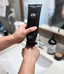 Close-up of S1N Care fragrance-free body lotion in sleek black tube, 6.8 fl oz/200ml, being dispensed onto hand in bathroom